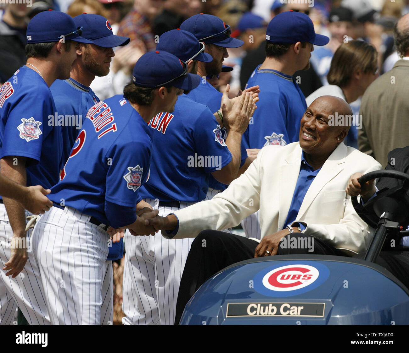 Former Chicago Cubs pitcher Ferguson Jenkins (R) shakes hands with Ryan  Theriot after Jenkins and Greg Maddux's number 31 was retired in a ceremony  before the game against the Florida Marlins at