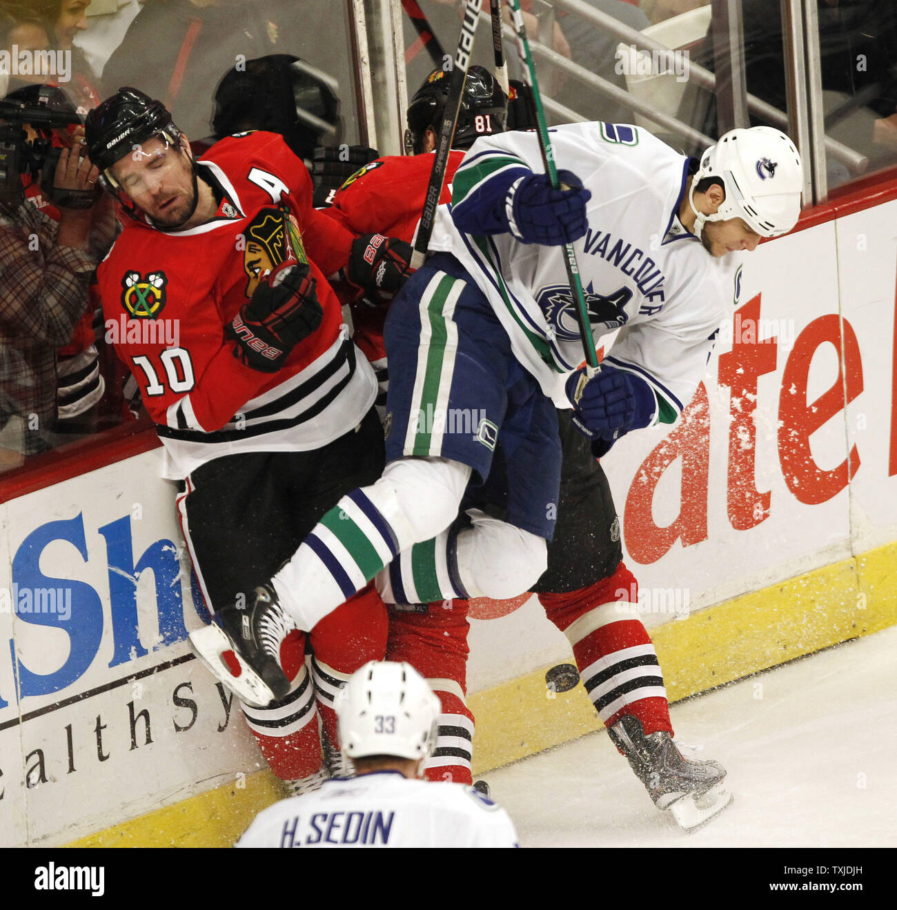 Kevin Bieksa 8X10 Canucks Home Jersey (Skating With Puck Crowd in Back)