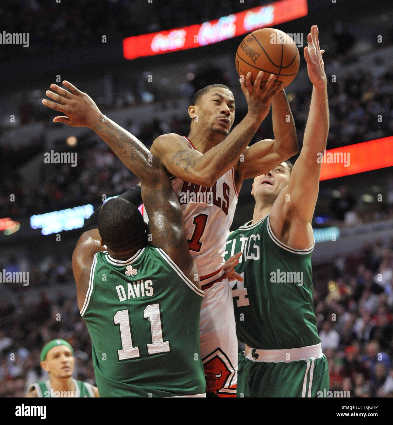 Chicago Bulls guard Derrick Rose (C) fouls Boston Celtics forward Glen Davis (L) as he drives to the basket past center Nenad Krstic of Serbia during the fourth quarter at the United Center in Chicago on April 7, 2011. The Bulls won 97-81.     UPI/Brian Kersey Stock Photo