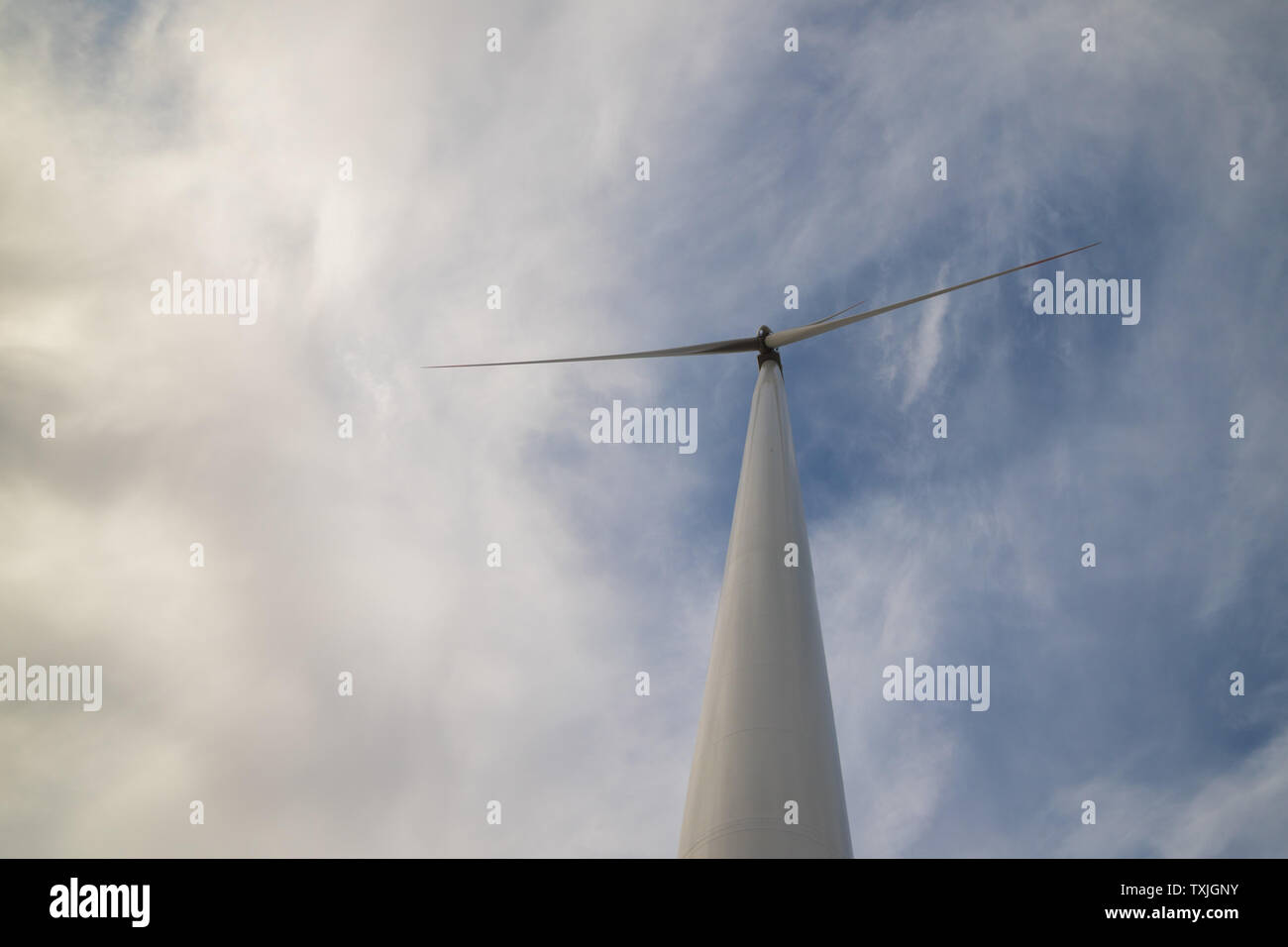 One wind turbine with cloudy sky in background Stock Photo - Alamy