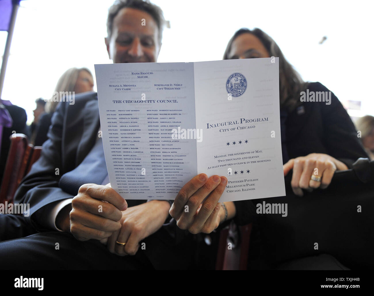 U.S. Treasury Secretary Timothy Geithner (L) and his wife Carole read the program for Rahm Emanuel's inauguration as mayor of Chicago at Millennium Park on May 16, 2011. Emanuel takes over for Richard M. Daley, who had served in the post since 1989.     UPI/Brian Kersey Stock Photo