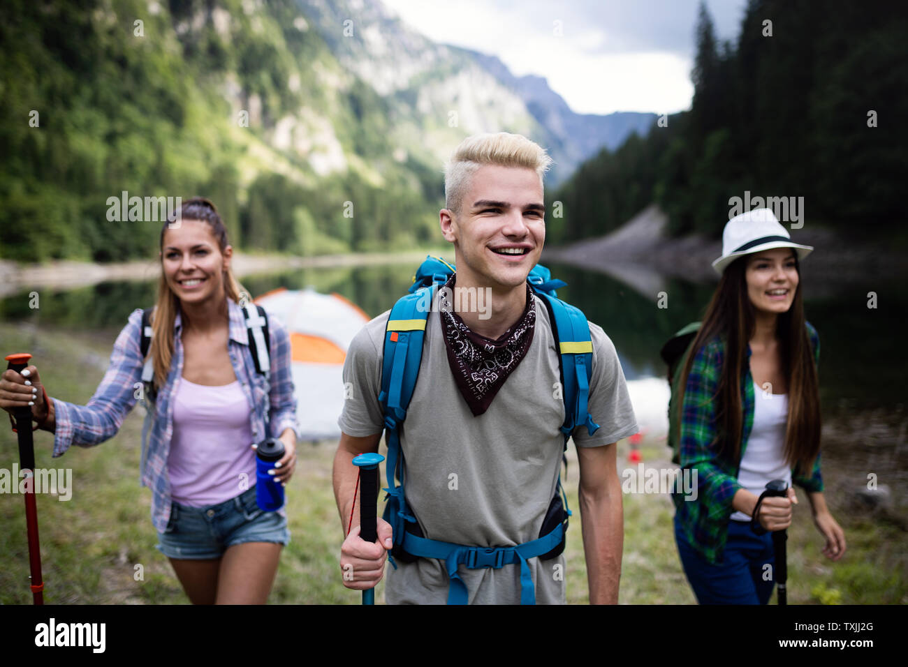 Group of young friends hiking in countryside. Multiracial happy people ...