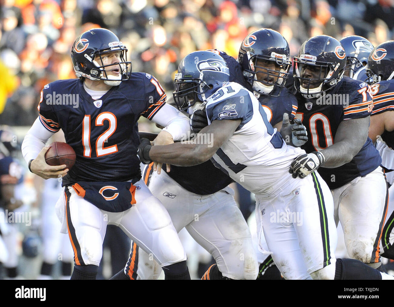 Seattle Seahawks defensive end Chris Clemons (91) sacks Chicago Bears  quarterback Caleb Hanie (12) for a 6-yard loss as Bears offensive tackle  J'Marcus Webb (73) and guard Edwin Williams (R) try to