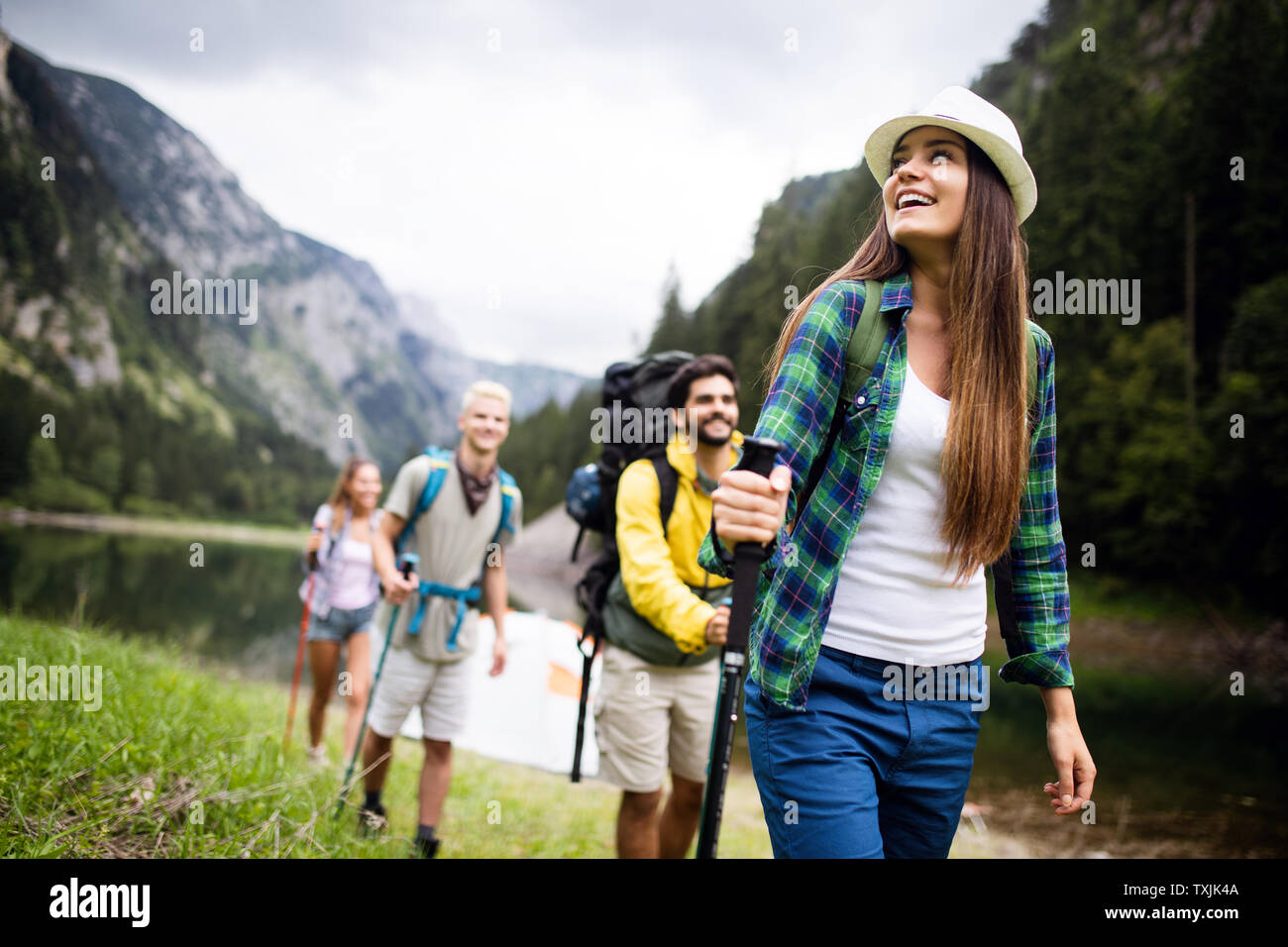 Group of young friends hiking in countryside. Multiracial happy people ...