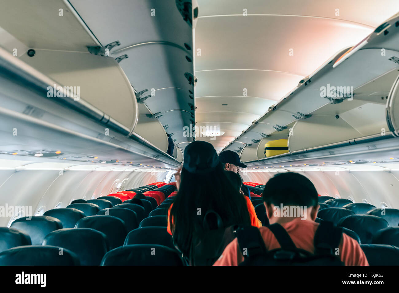 Unspecified passengers were walking out of the plane following the exit sign Stock Photo