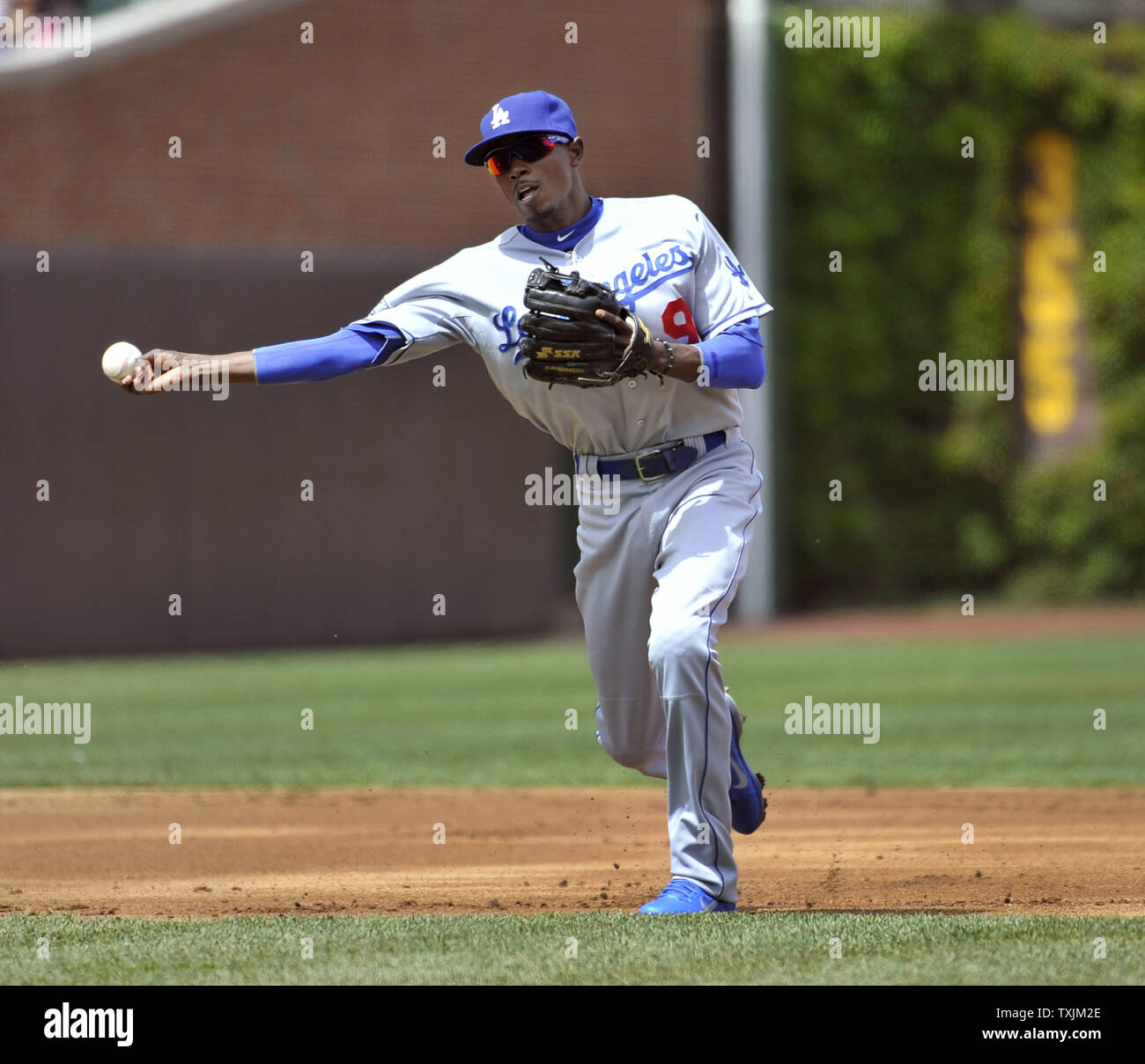 Los Angeles Dodgers shortstop Dee Gordon throws to first base to
