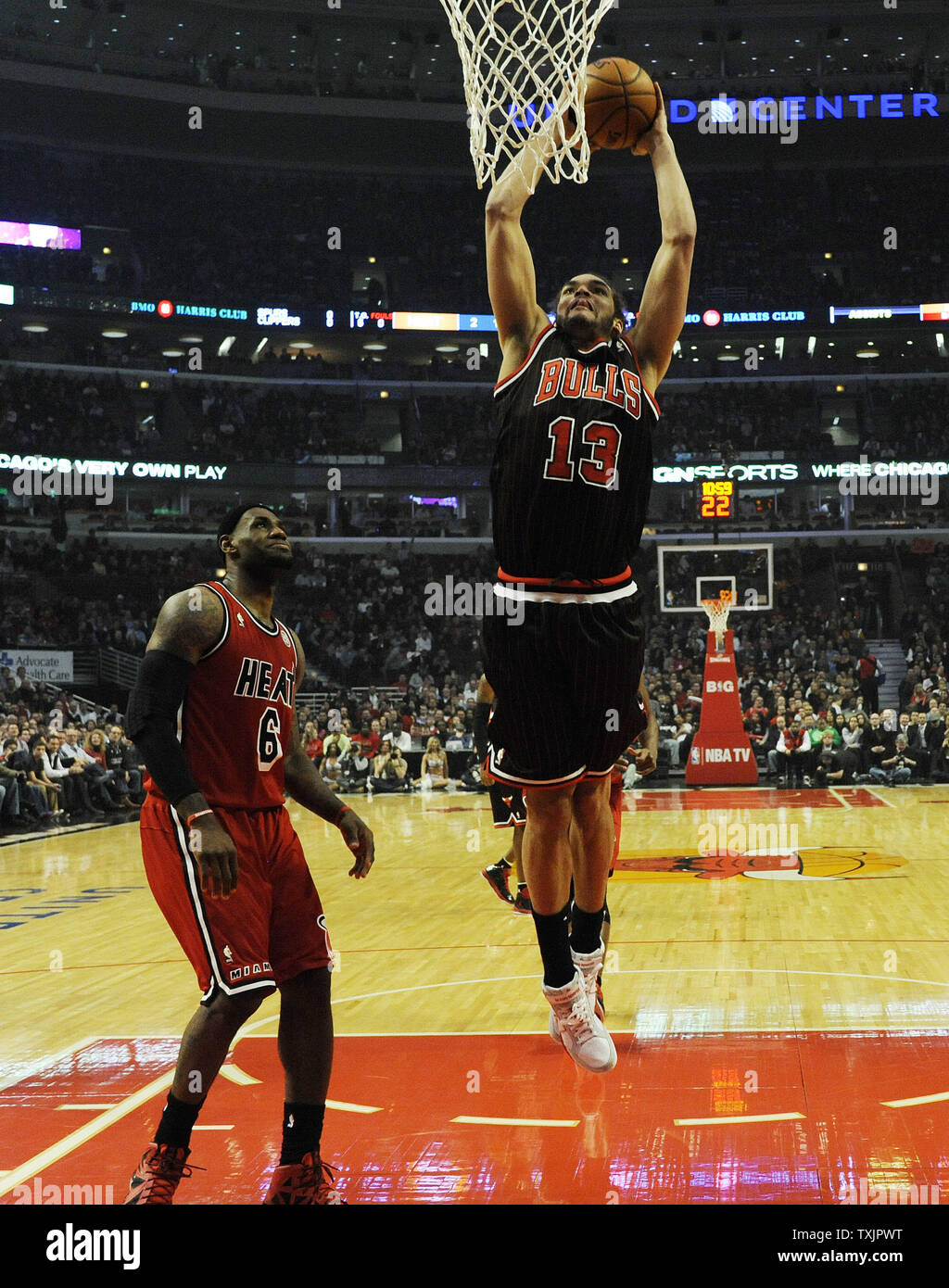 Chicago Bulls center Joakim Noah (13) dunks the ball over Miami Heat small  forward LeBron James (