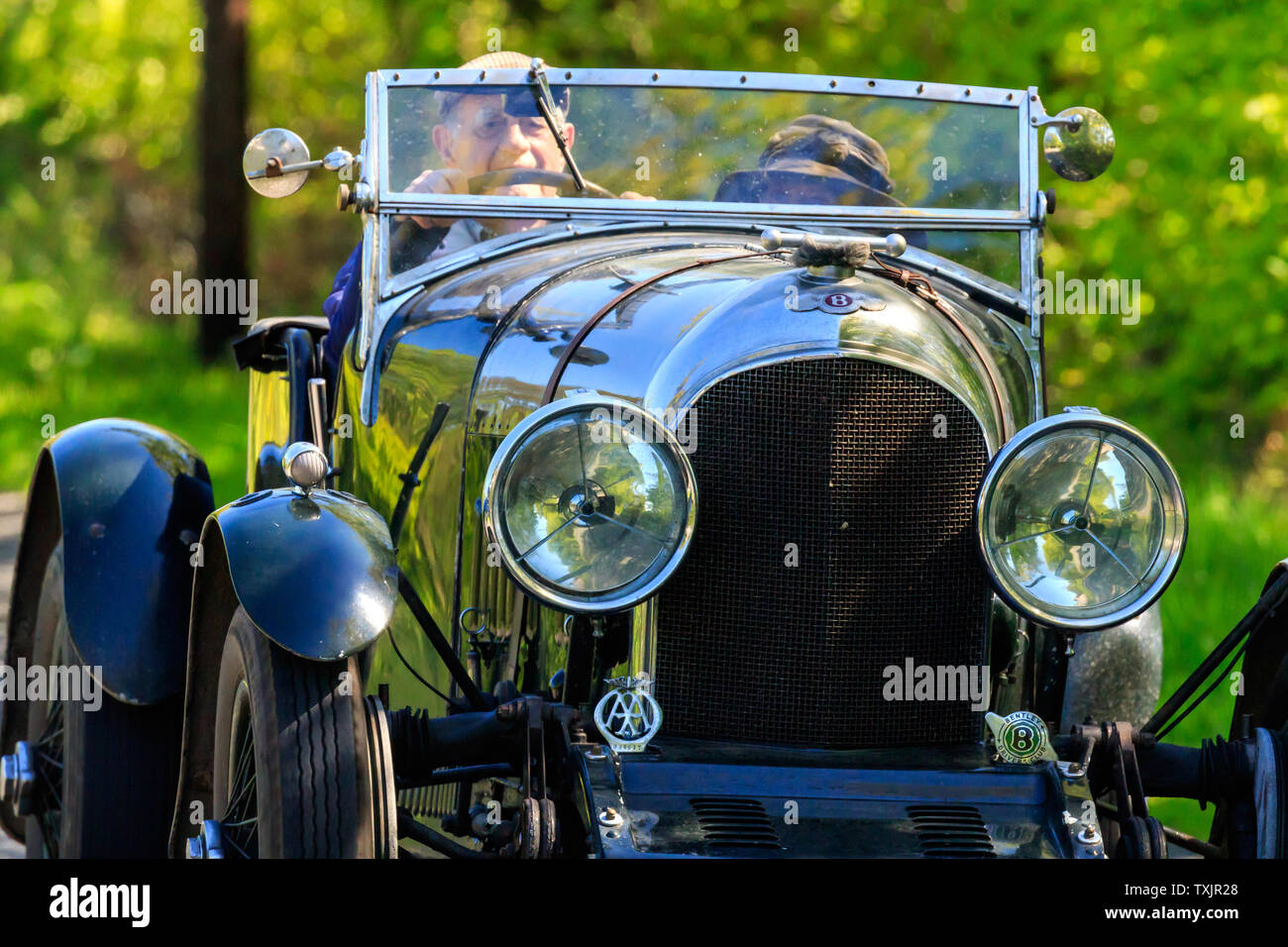 Vintage Bentley car traveling on a country lane towards the village of  Brydekirk Dumfriesshire Stock Photo