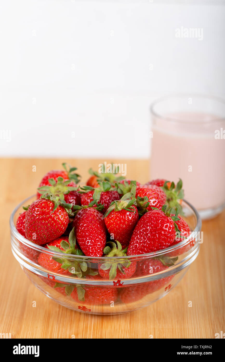Fresh strawberries in a glass bowl and a glass of strawberry milk Stock ...