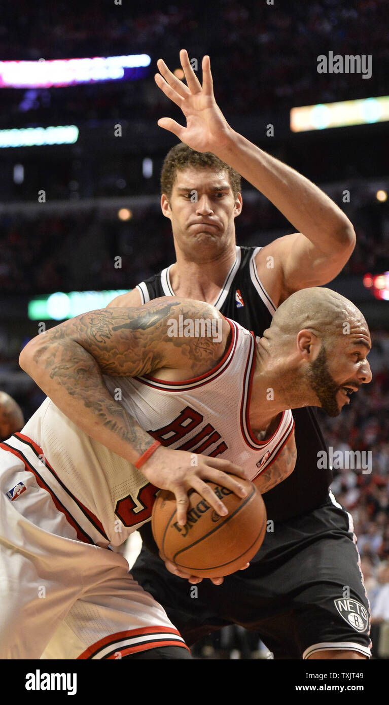 Chicago Bulls forward Carlos Boozer (L) drives on Brooklyn Nets center Brook Lopez during the fourth quarter of game 3 of the NBA Eastern Conference Quarterfinals during the 2013 NBA Playoffs at the United Center in Chicago on April 25, 2013. The Bulls won 79-76 and lead the best of seven series 2-1.     UPI/Brian Kersey Stock Photo