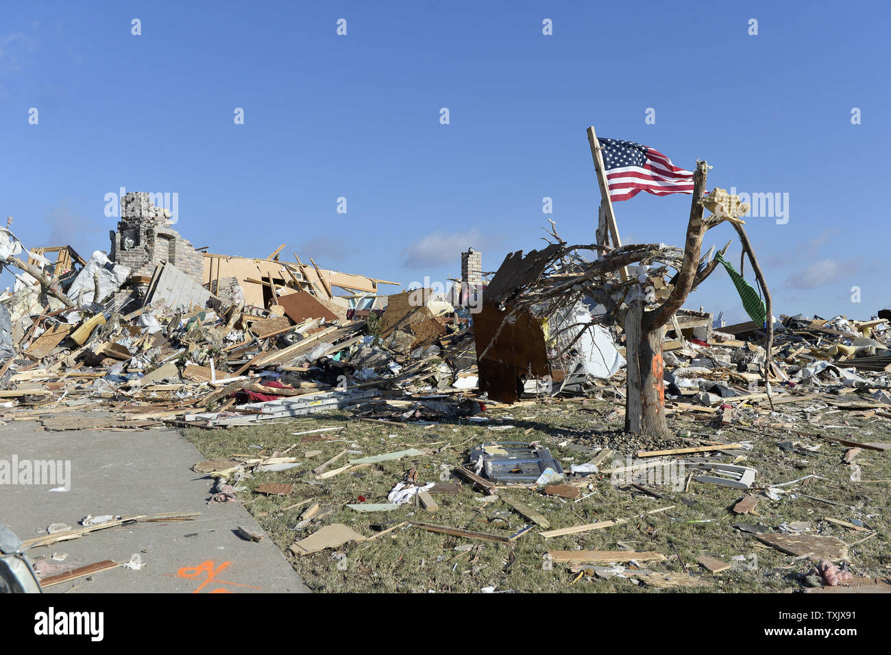 An American flag flies in front of a destroyed house in Washington, Illinois on November 18, 2013. Six people died and hundreds of homes were destroyed in Illinois as 81 tornadoes were sighted on November 17 throughout 12 midwest states including the EF4 tornado that struck Washington, Illinois.     UPI/Brian Kersey.     UPI/Brian Kersey Stock Photo