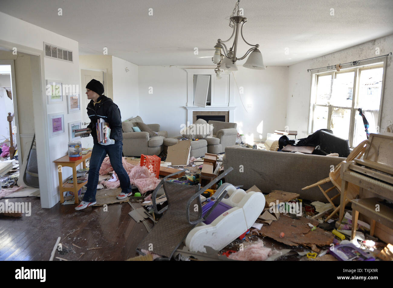 Helen Potts sorts through her belongings in her living room in Washington, Illinois on November 18, 2013. Six people died and hundreds of homes were destroyed in Illinois as 81 tornadoes were sighted on November 17 throughout 12 midwest states including the EF4 tornado that struck Washington, Illinois.     UPI/Brian Kersey.     UPI/Brian Kersey Stock Photo