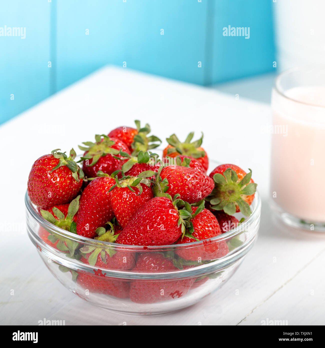 Fresh strawberries in a glass bowl and a glass of strawberry milk Stock ...