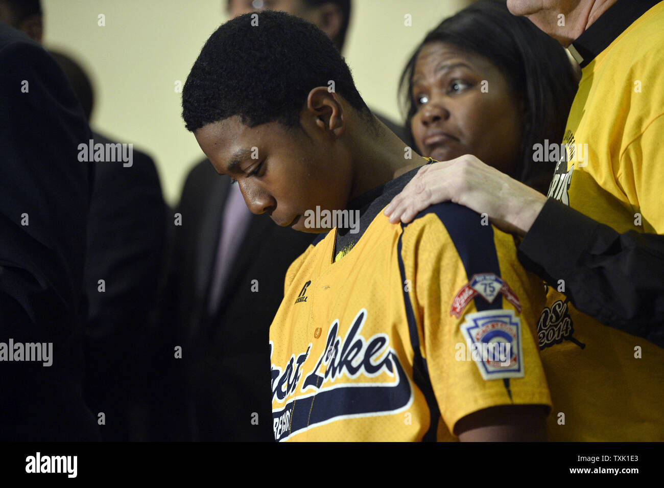 Jackie Robinson West little leaguer Brandon Green stands listens to speakers at a news conference called by reverends Jesse Jackson and Michael Pfleger at Operation Push Headquarters on February 11, 2015 in Chicago. Little League Baseball announced Wednesday that Jackie Robinson West used a falsified boundary map to claim players from other districts and must vacate wins from the 2014 Little League Baseball International Tournament, including its Great Lakes Regional and United States championships. Jackson and Pfleger alleged that Jackie Robinson West faced unequal scrutiny as the only all-Af Stock Photo