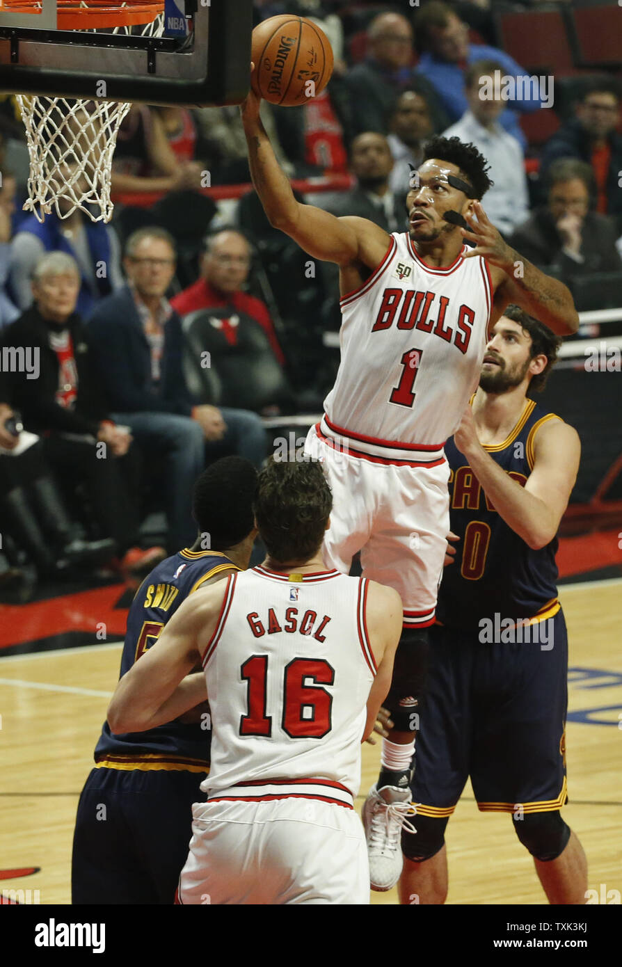 Chicago Bulls guard Derrick Rose 1 goes to the basket in front of Cleveland Cavaliers forward Kevin Love 0 during the first half of their NBA game at the United Center on