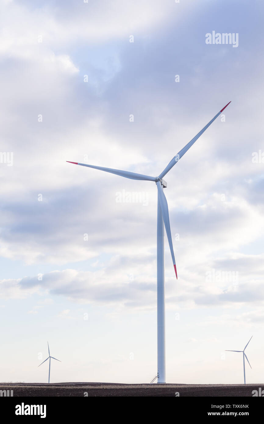 Wind turbine with cloudy sky in background Stock Photo - Alamy
