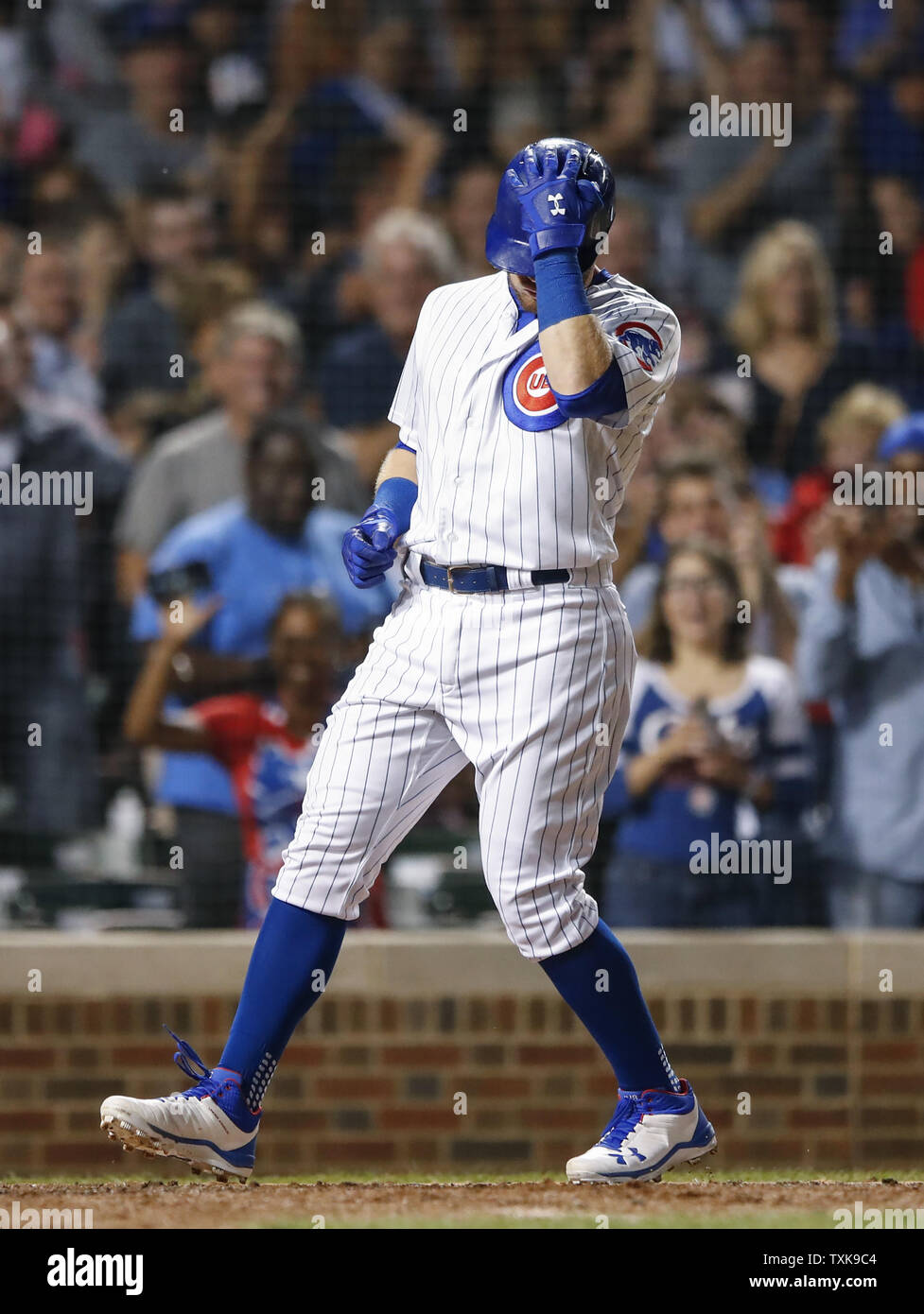 Chicago Cubs center fielder Ian Happ crosses home plate after hitting  three-run home run against the Cincinnati Reds in the seventh inning at  Wrigley Field on September 14, 2018 in Chicago. Photo
