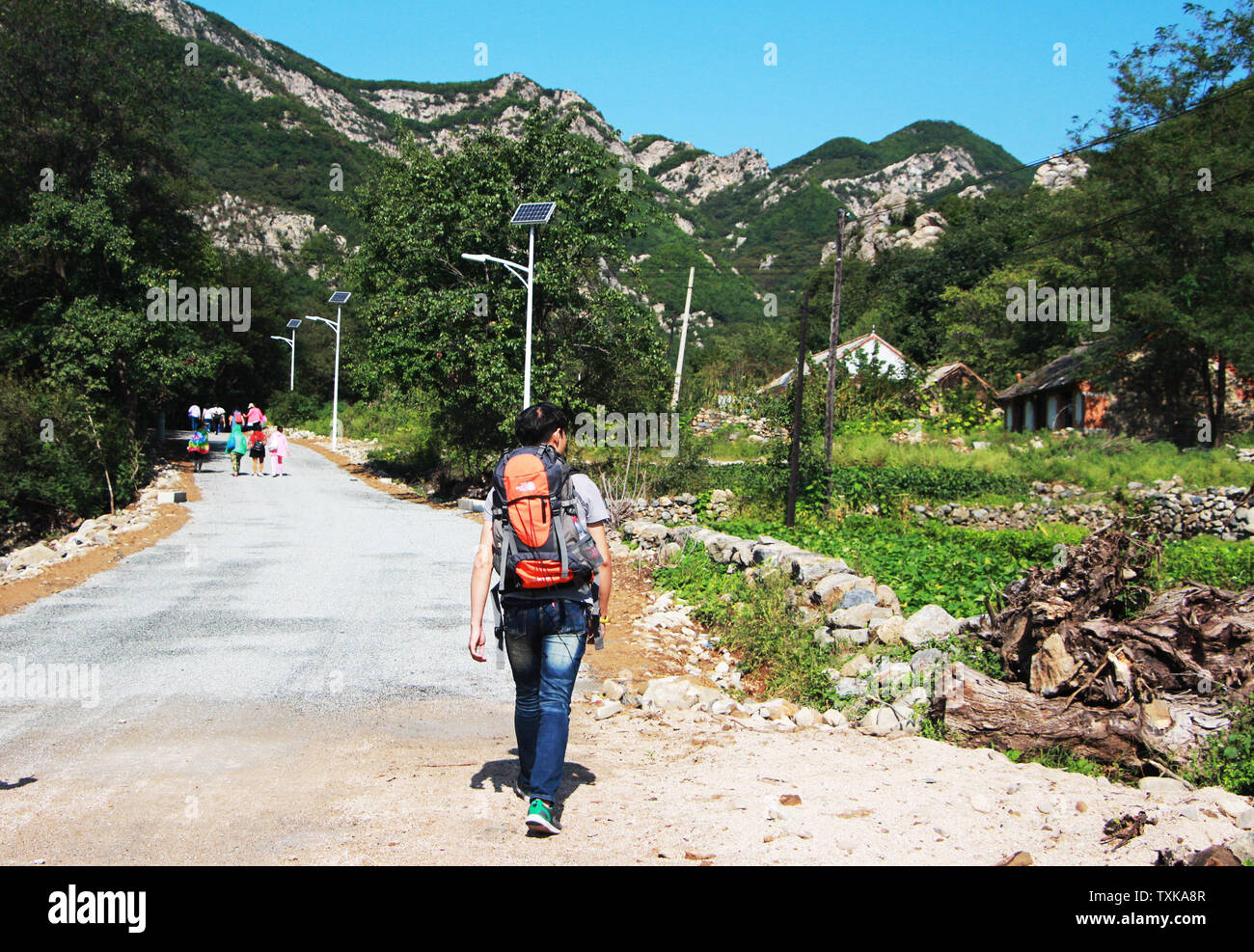 A person went on a trip alone, carrying a mountaineering bag, sunny, in a good mood Stock Photo
