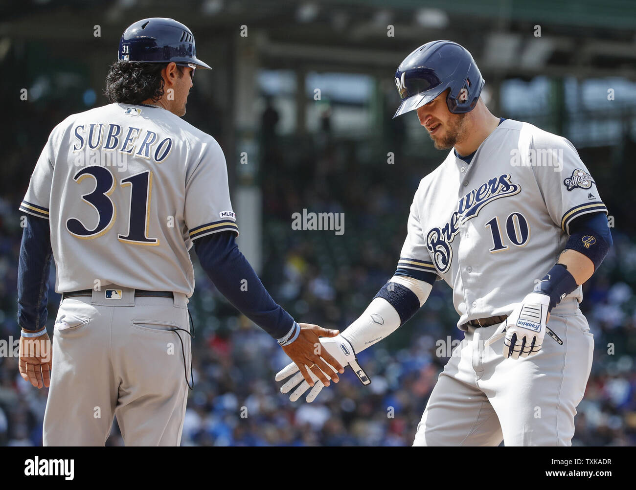 Milwaukee Brewers' Yasmani Grandal (R) celebrates with first base coach Carlos Subero (L) after hitting a single against the Chicago Cubs in the seventh inning at Wrigley Field on May 10, 2019 in Chicago. Photo by Kamil Krzaczynski/UPI Stock Photo