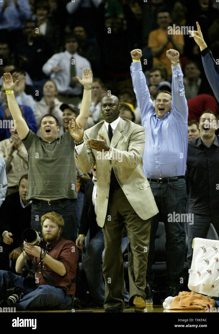 Charlotte Bobcats part owner and managing member of basketball operations Michael Jordan, center, applauds the effort of his Charlotte Bobcats as they defeat the Boston Celtics 114-106 in overtime in Charlotte, North Carolina on January 6, 2009. (UPI Photo/Nell Redmond) Stock Photo