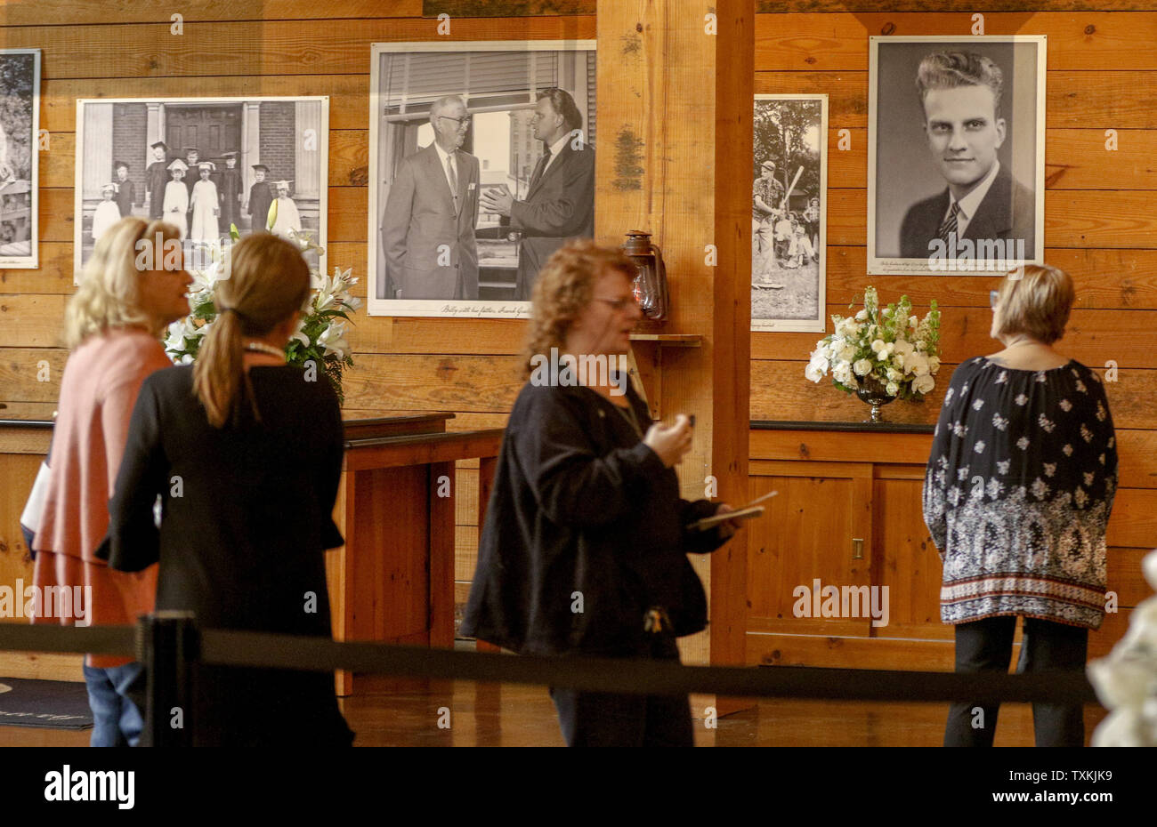 Visitors walk past photos of evangelist Billy Graham at the Billy Graham Library in Charlotte, North Carolina on February 26, 2018. Mourners are visiting the site after Graham died on February 21, 2018.   Photo by Nell Redmond/UPI Stock Photo