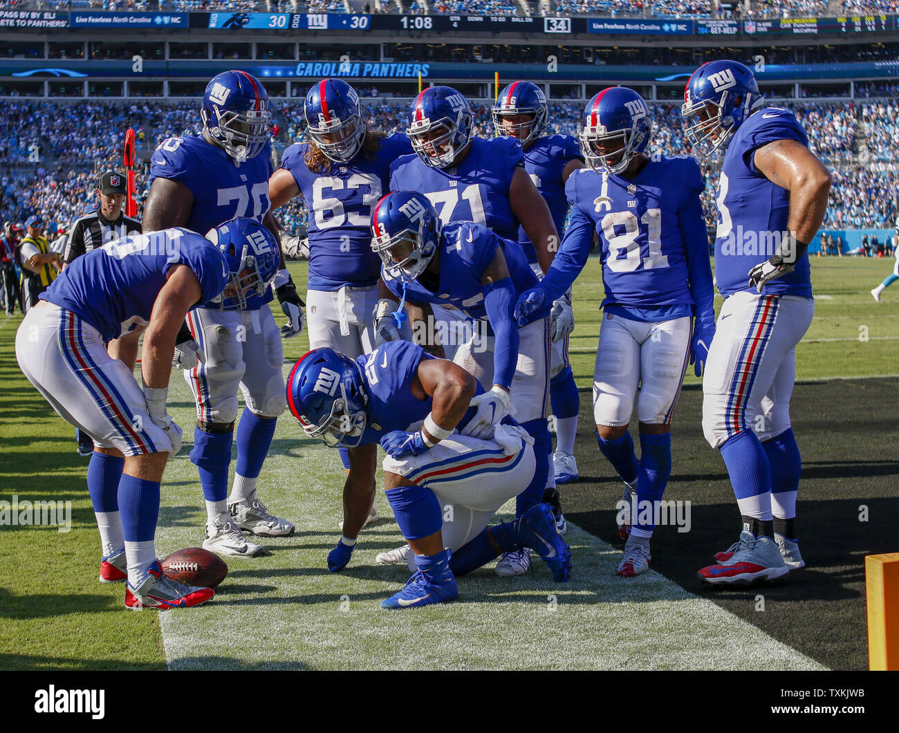 New York Giants players surround running back Saquon Barkley (kneeling)  after he scores a touchdown against the Carolina Panthers in the second  half of an NFL football game in Charlotte, North Carolina