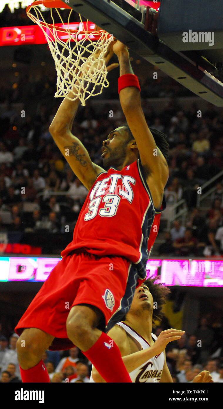 New Jersey Nets Mikki Moore (33) hangs on the rim after losing the ball to  Cleveland Cavaliers Anderson Varejao en route to a dunk in the fourth  quarter of game five of, image size:759x1390