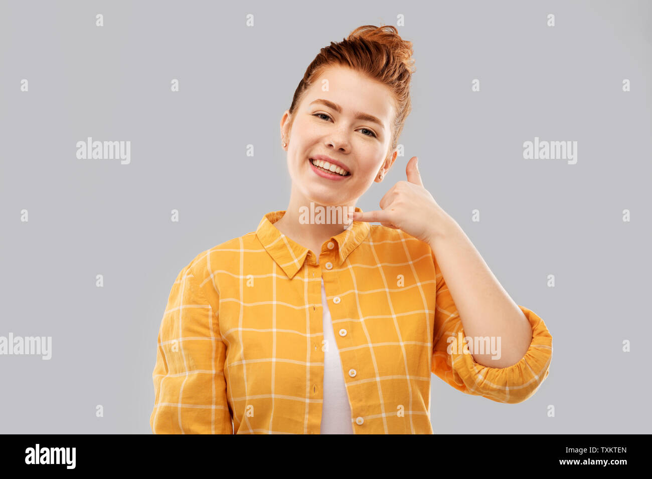 redhead teenage girl making phone call gesture Stock Photo