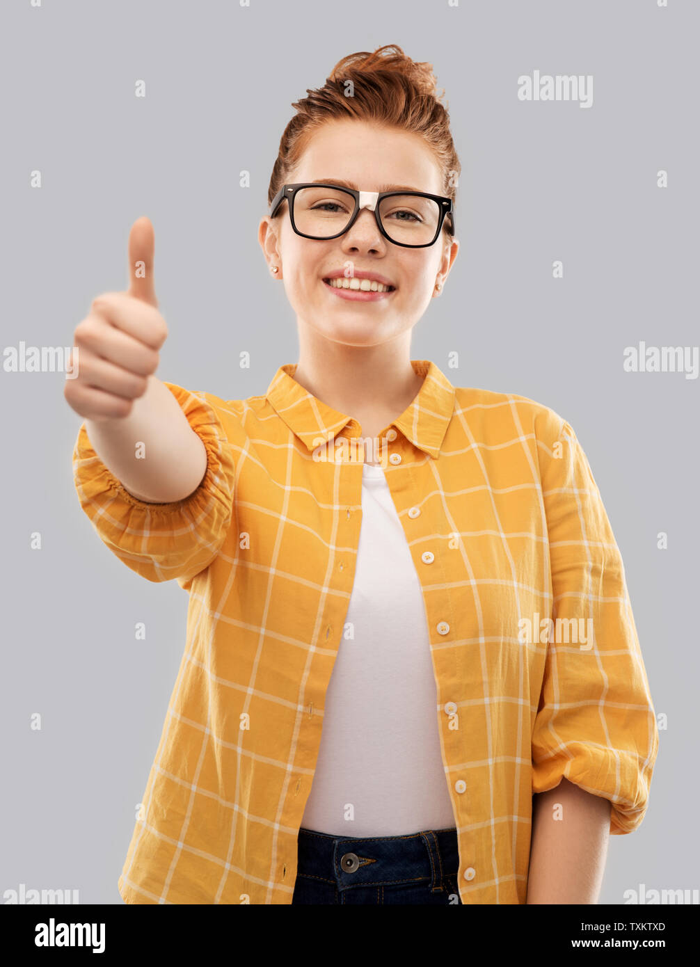 redhead student girl in glasses showing thumbs up Stock Photo - Alamy