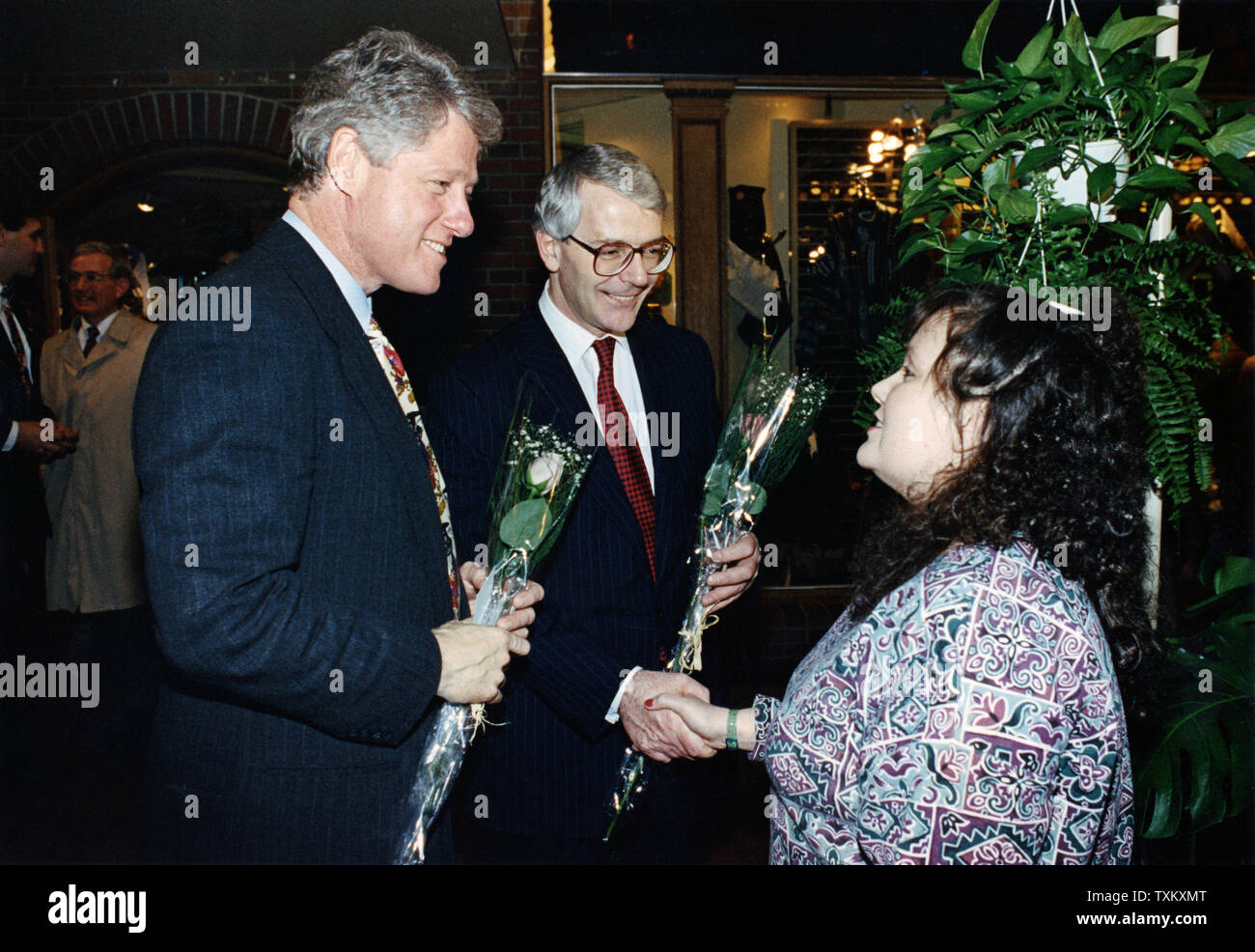 President Bill Clinton and British Prime Minister John Major receive flowers from flower shop clerk Leslie Taffel in Pittsburgh, Pennsylvania on February 28, 1994. UPI/Cliff Owen Stock Photo