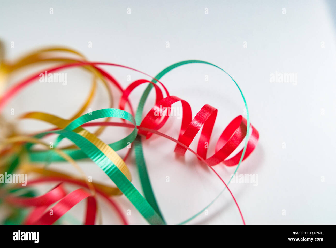 Red, gold and green wrapping ribbon curled isolated on white background. Stock Photo