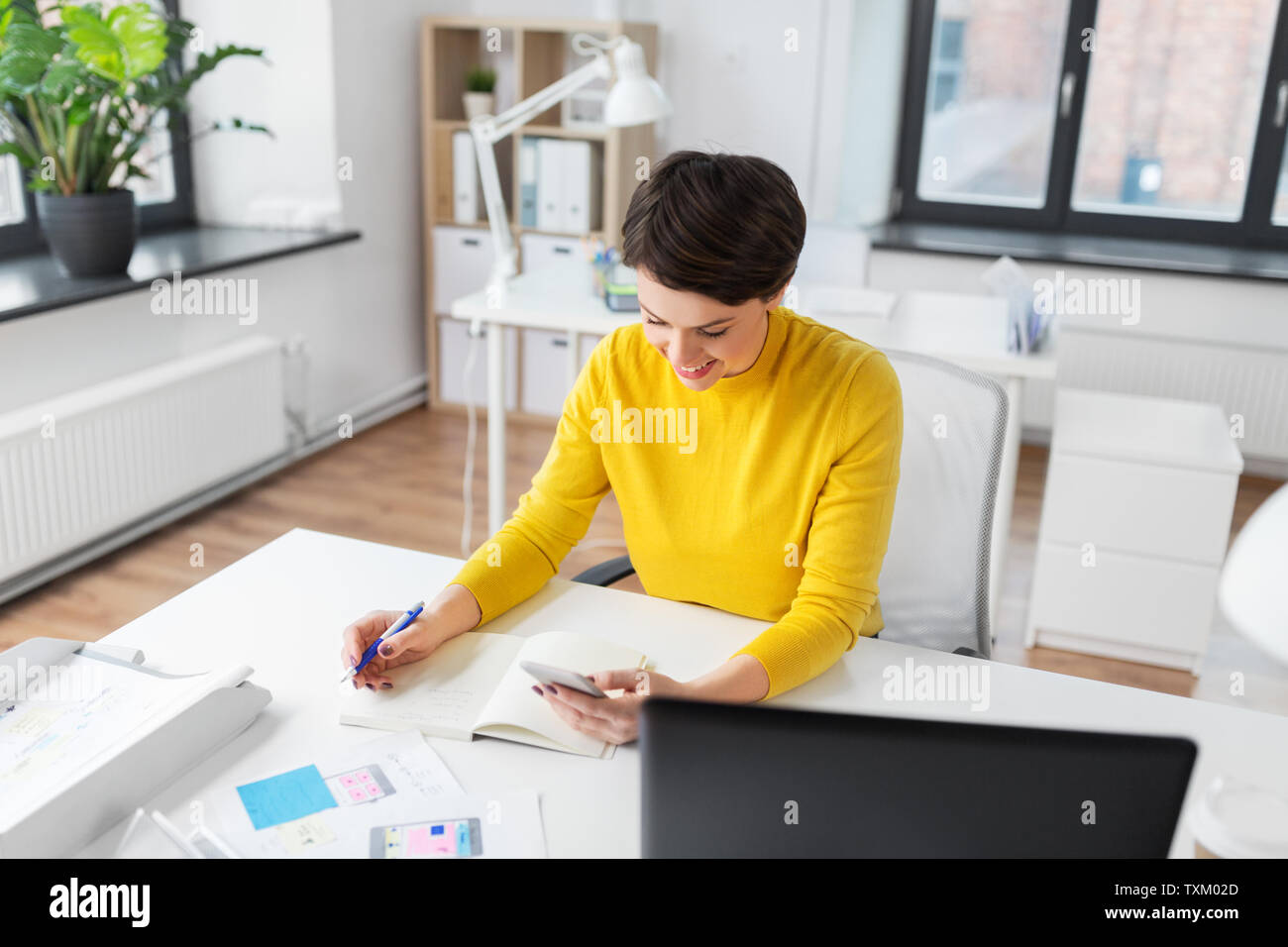 smiling ui designer using smartphone at office Stock Photo
