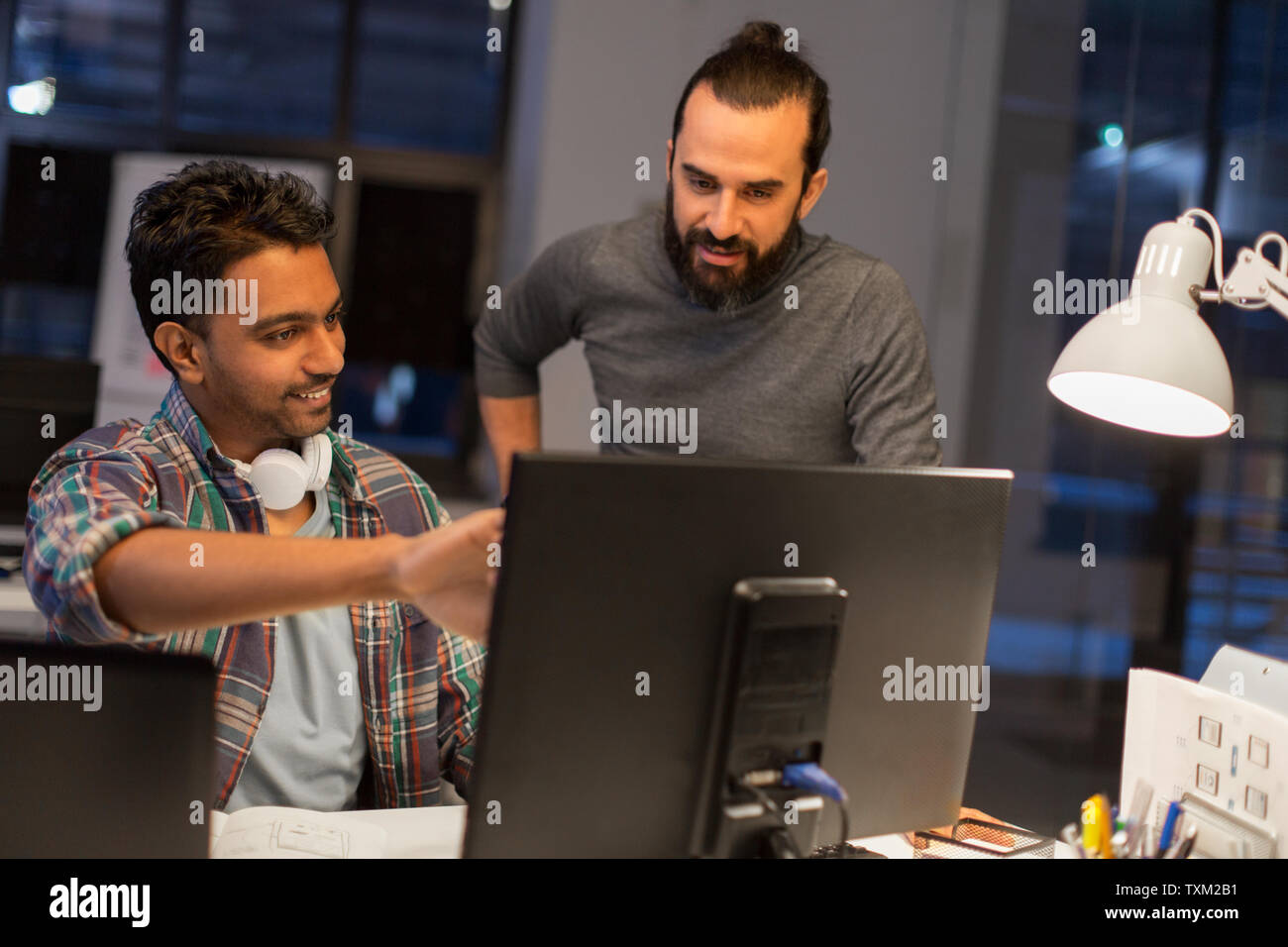 creative team with computer working late at office Stock Photo