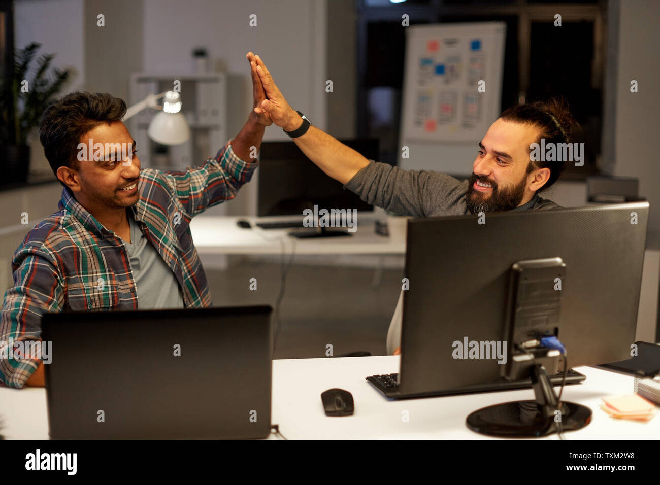 creative team making high five at night office Stock Photo