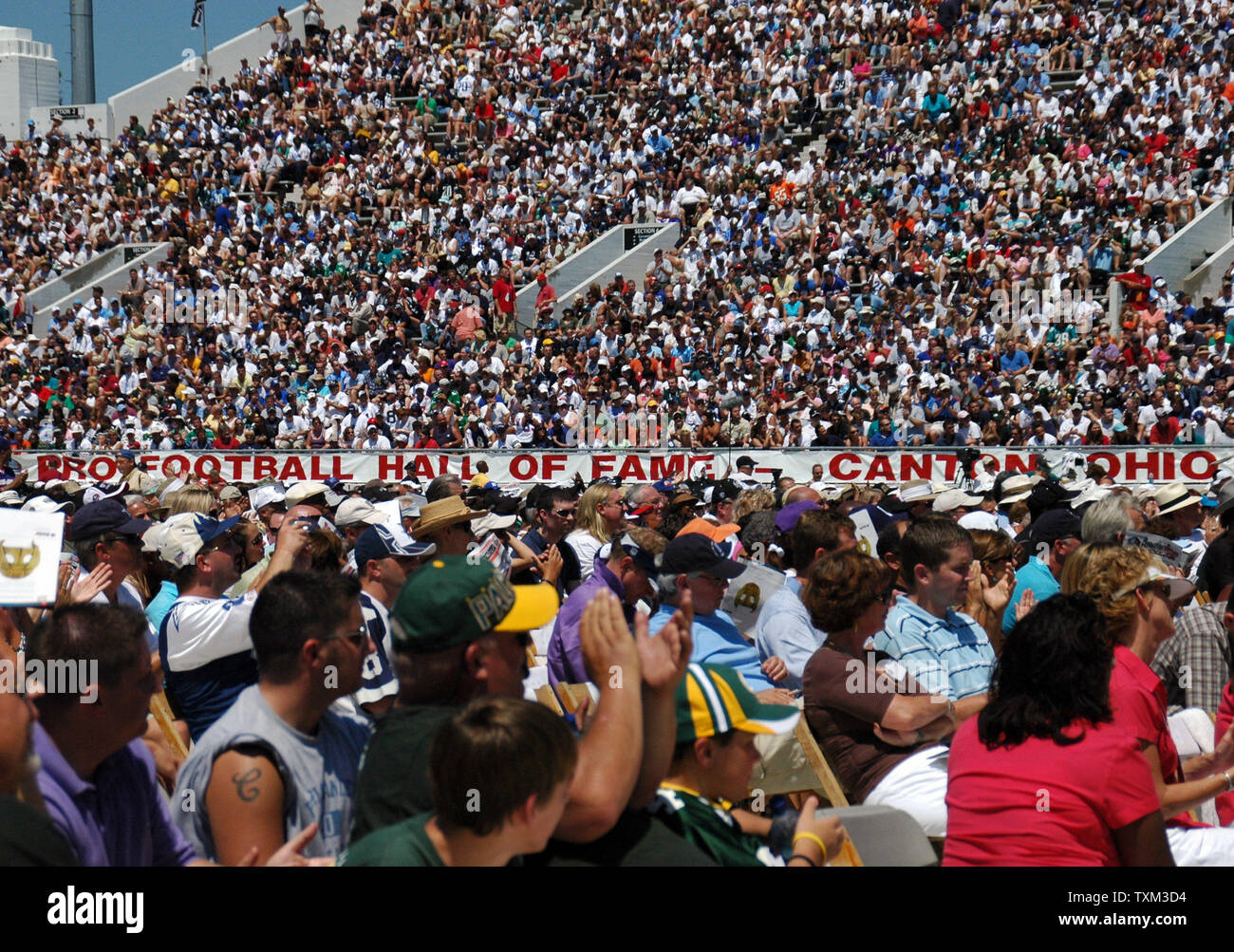 Football fans pack the stands on a very hot and sunny day at the