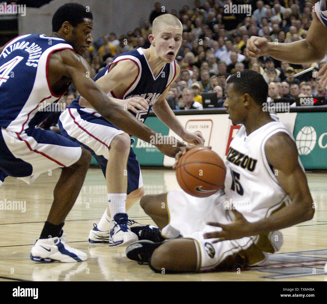 Missouri Tigers Marshall Brown (R) goes to the floor for a loose ball as Gonzaga Bulldogs'  P. M. Altidor-Cespedes (L) and Dereck Raivio also give chase in the second half at the Mizzou Arena in Columbia, MO on December 30, 2004. (UPI Photo/Bill Greenblatt) Stock Photo