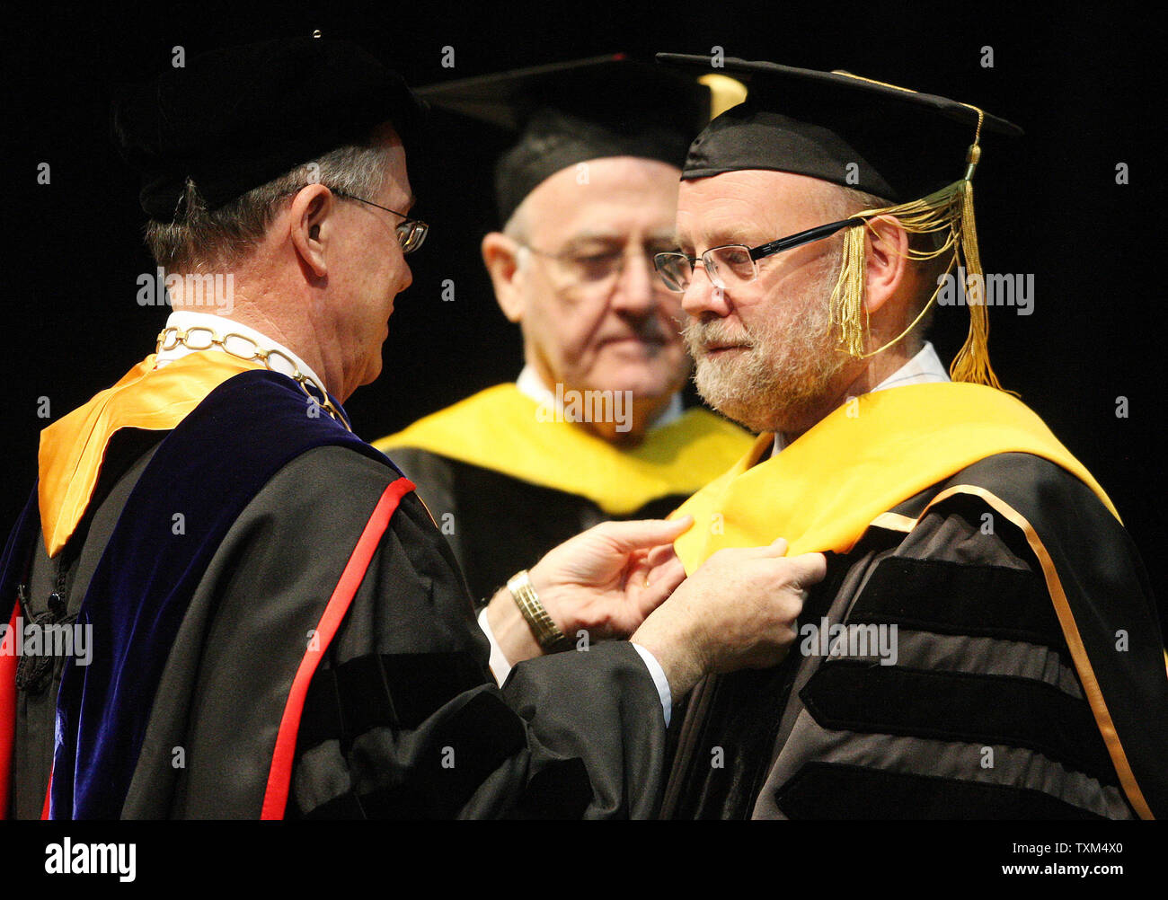 Sir Ian Wilmut, best known for leading a team of scientists to produce the first mammal cloned with genetic material from an adult cell (R) receives a hood from Chancellor Brady Deaton at Commencement Honors Convocation ceremonies at the University of Missouri in Columbia, Missouri on May 14, 2011. Wilmut, who named the sheep 'Dolly'  in 1996 after singer Dolly Parton, says the birth sparked debate about the ethics of cloning. Wilmut was awarded a Doctor of Science Honorary Degree.  UPI/Bill Greenblatt Stock Photo