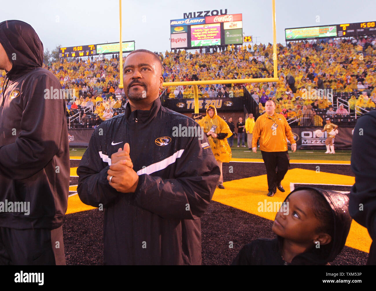 Missouri Tigers head basketball coach Frank Haith watches a video board while his daughter Brianna keeps an eye on her dad, during team introductions during the Alabama - Missouri football game at Faurot Field in Columbia, Missouri on October 13, 2012.   UPI/Bill Greenblatt Stock Photo