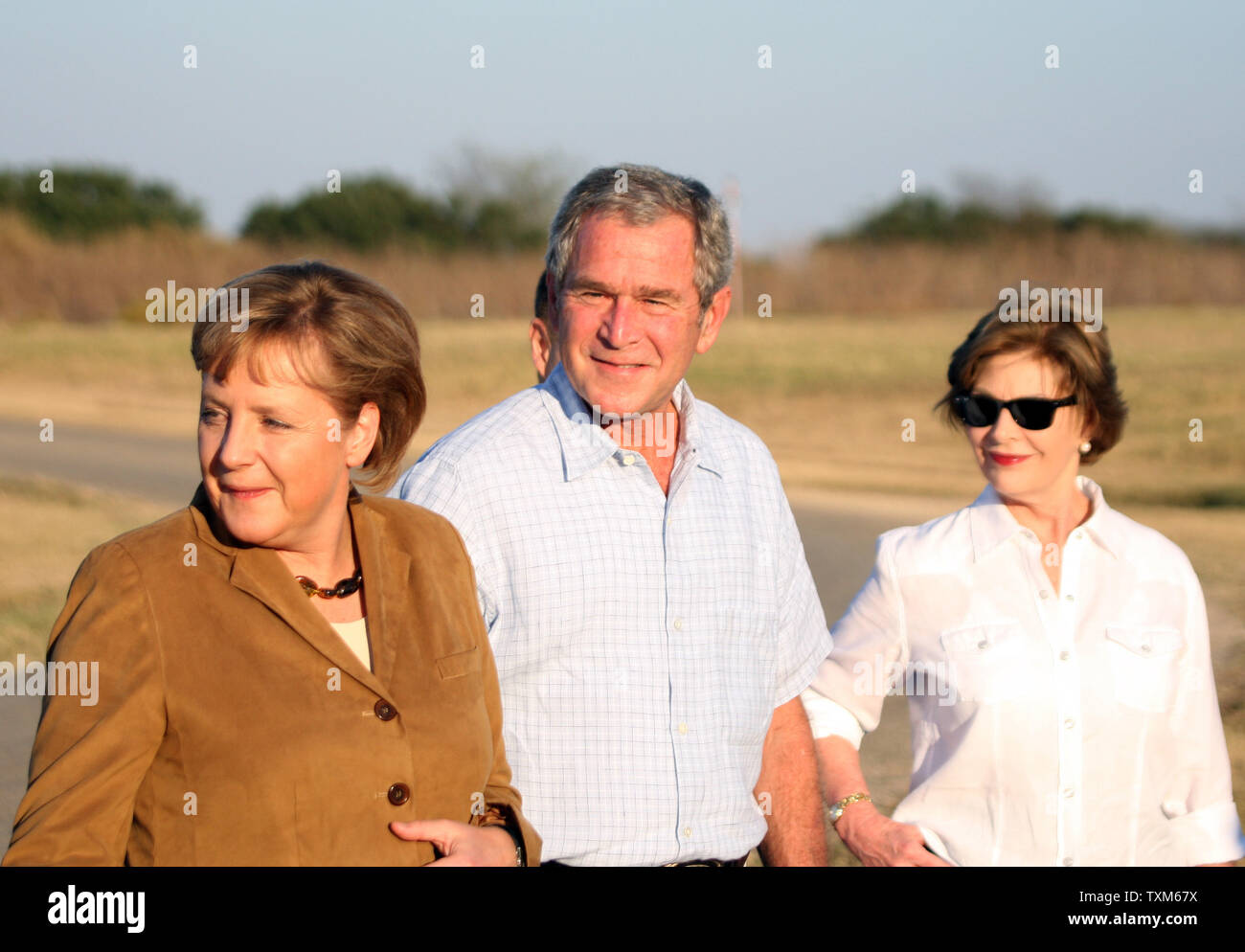 U.S. President George W. Bush (C) walks with German Chancellor Angela Merkel (L) and First Lady Laura Bush at Bush's ranch in Crawford, Texas on November 9, 2007.  (UPI Photo/Ron Russek II) Stock Photo