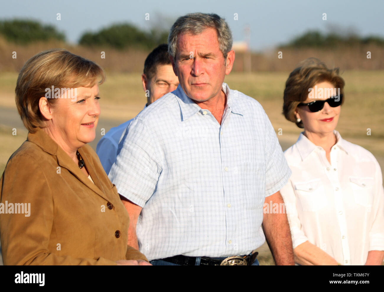 U.S. President George W. Bush (C) walks with German Chancellor Angela Merkel (L) and First Lady Laura Bush at Bush's ranch in Crawford, Texas on November 9, 2007.  (UPI Photo/Ron Russek II) Stock Photo