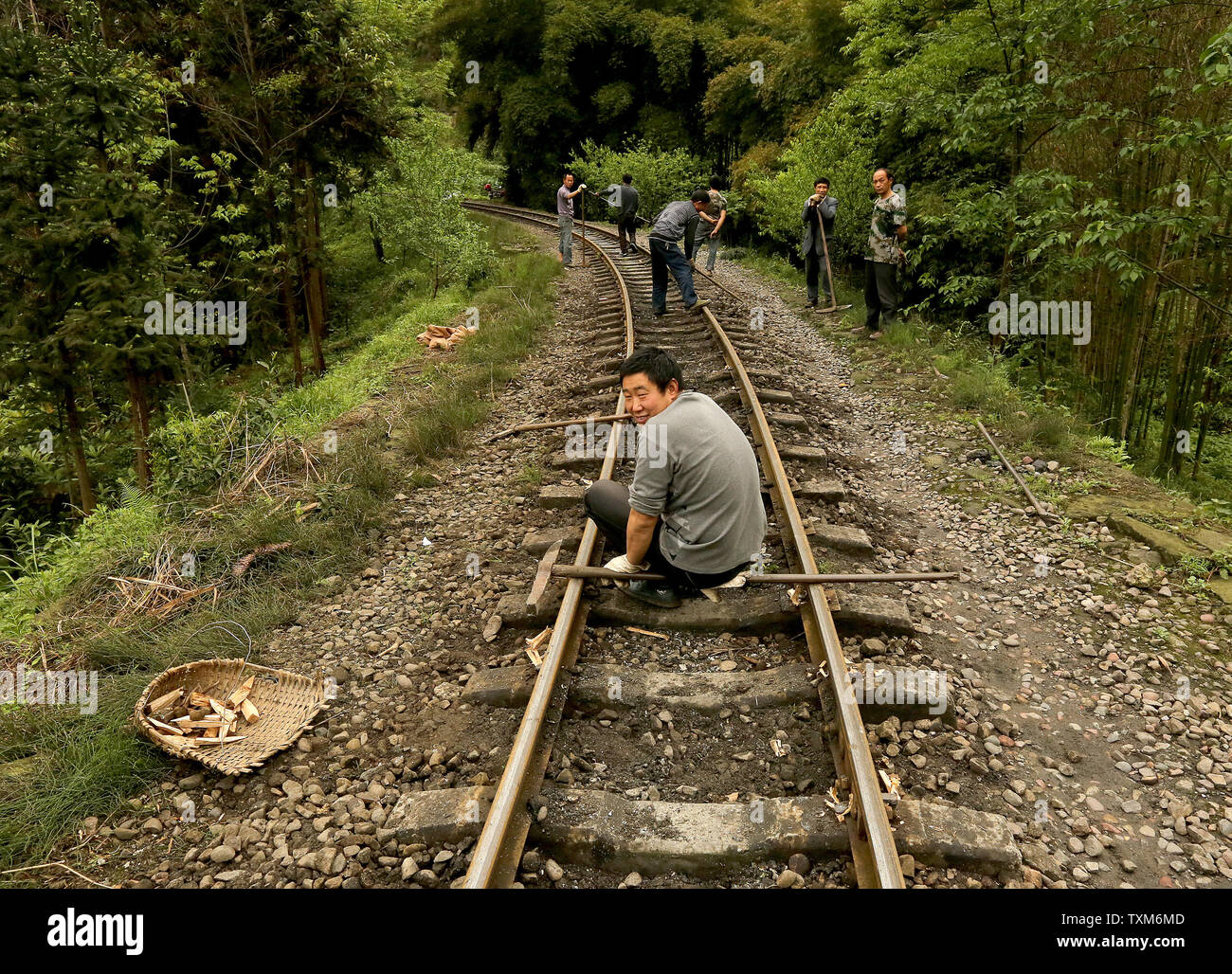 Chinese rail workers remove rocks from the narrow-gauge tracks used by ...