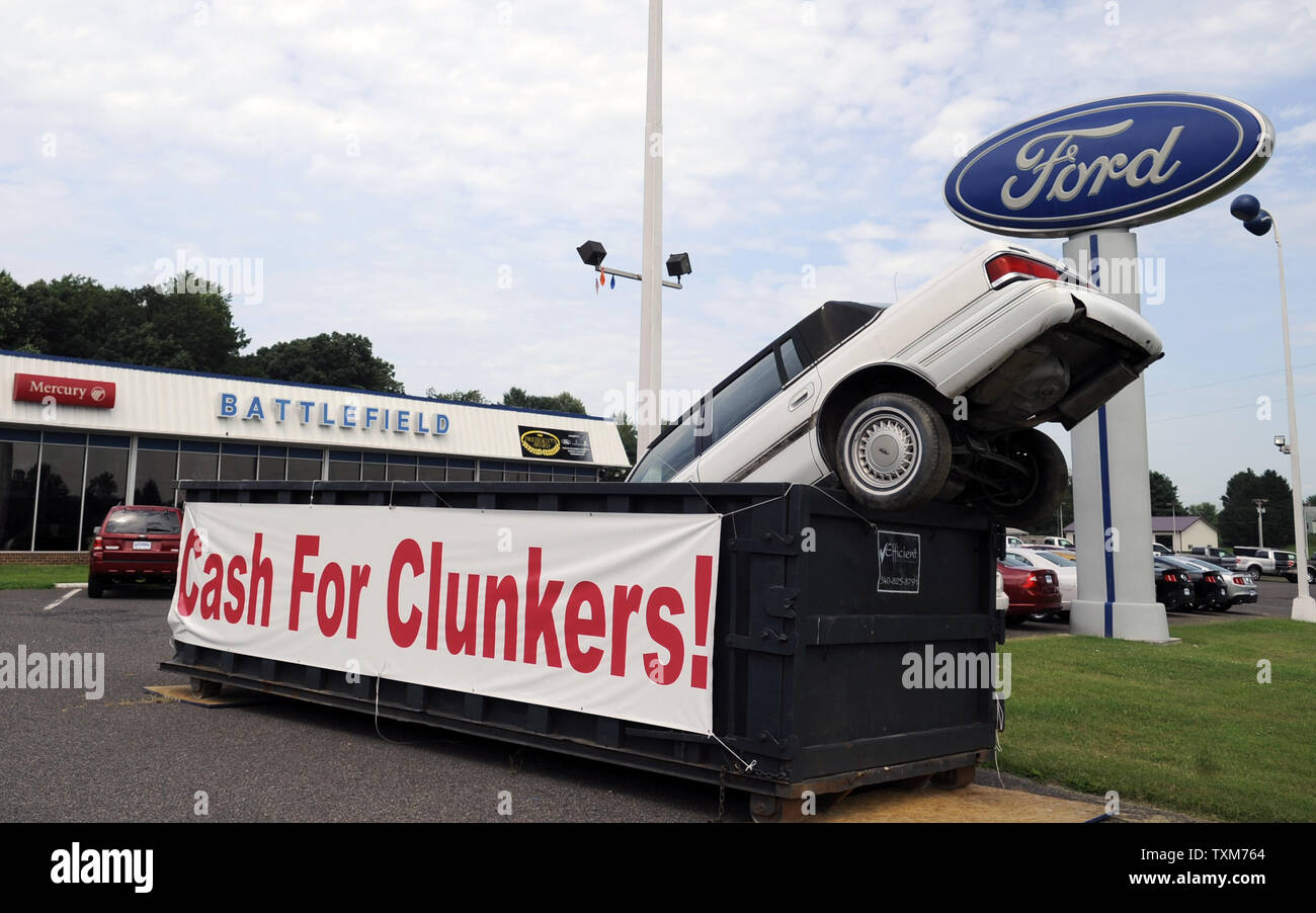 A display with a car in a dumpster at a Ford Auto Dealership advertises