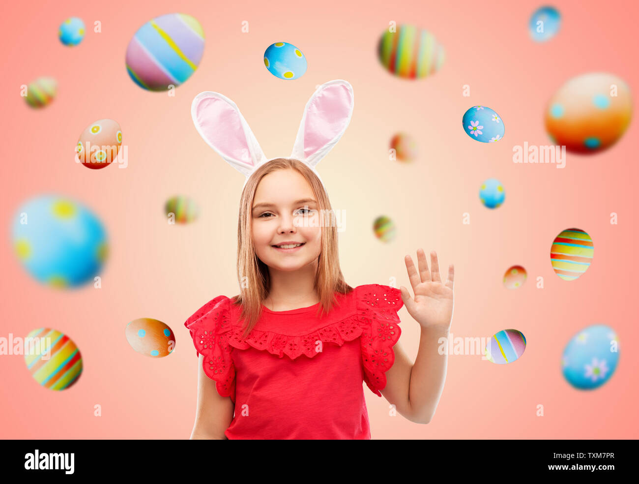 happy girl wearing easter bunny ears waving hand Stock Photo