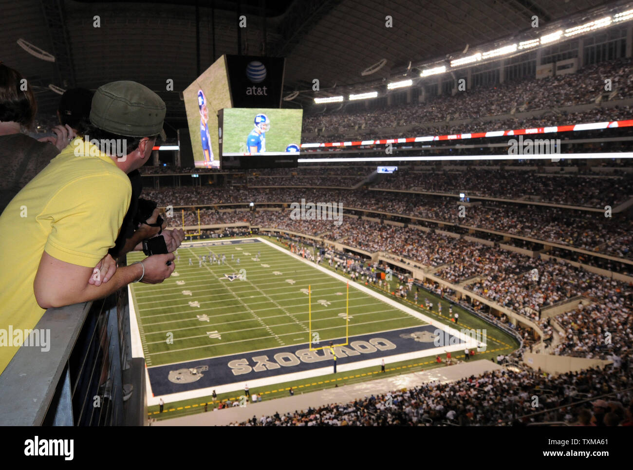 A fan watches the Dallas Cowboys battle the New York Giants on the stadium's giant video scoreboard September 21, 2009 in Arlington, Texas.   More than 100,000 fans filled the new $1.2 billion stadium for the first NFL game.   UPI/Ian Halperin Stock Photo