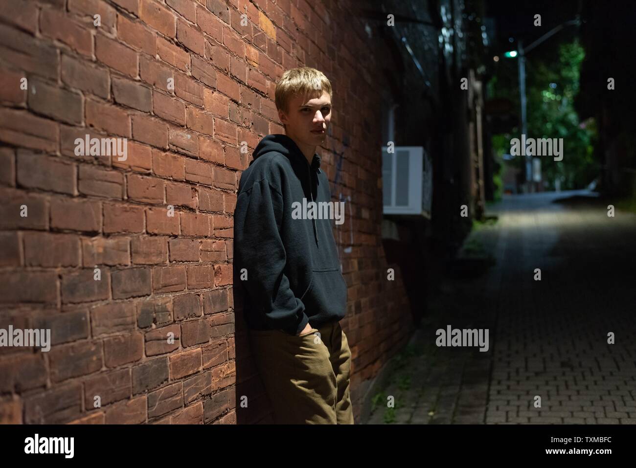 Serious Looking Teenager Leaning Against A Brick Wall In An Alleyway At Night Stock Photo Alamy Serious Looking Teenager Leaning Against A Brick Wall In An Alleyway At Night Stock Photo Alamy