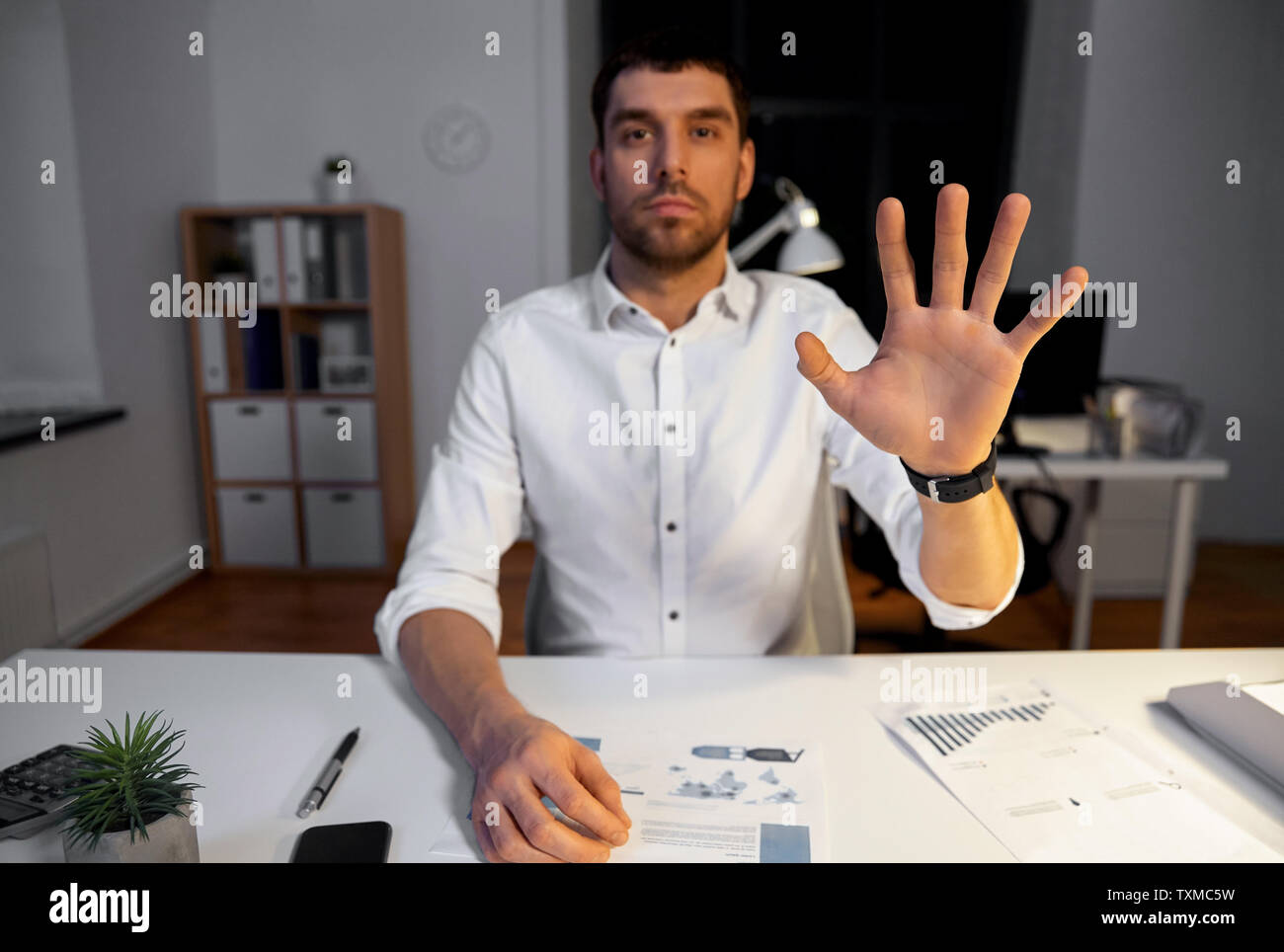 businessman using gestures at night office Stock Photo