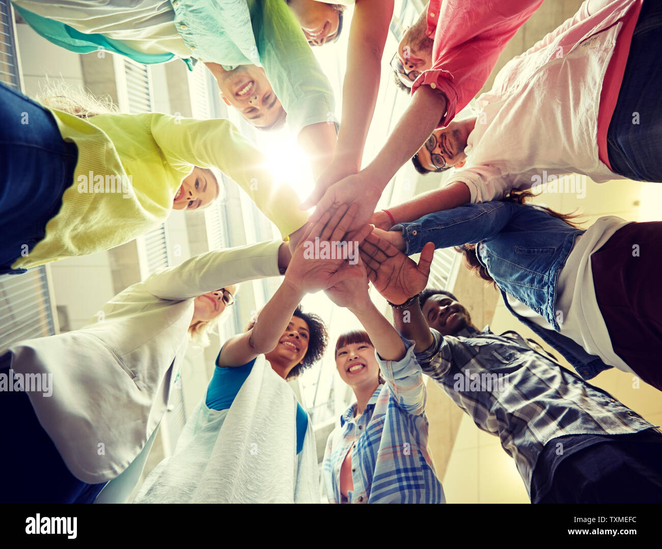 group of international students with hands on top Stock Photo - Alamy