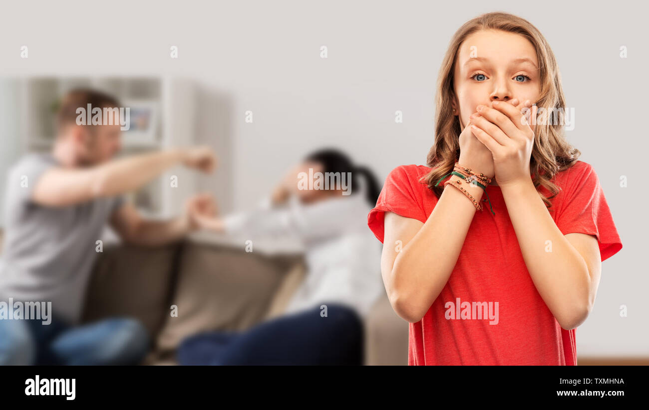 girl covering mouth over her parents having fight Stock Photo