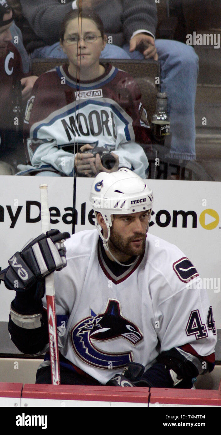 Vancouver Canucks right wing Todd Bertuzzi (front) sits on the bench in front of a Colorado Avalanche fan wearing a Steve Moore jersey at Pepsi Center in Denver on October 27, 2005.  Bertuzzi made his first appearance in Denver since hitting former Avalanche player Steve Moore and breaking his neck in a game in Vancouver March 8, 2004.   (UPI Photos/Gary C. Caskey) Stock Photo