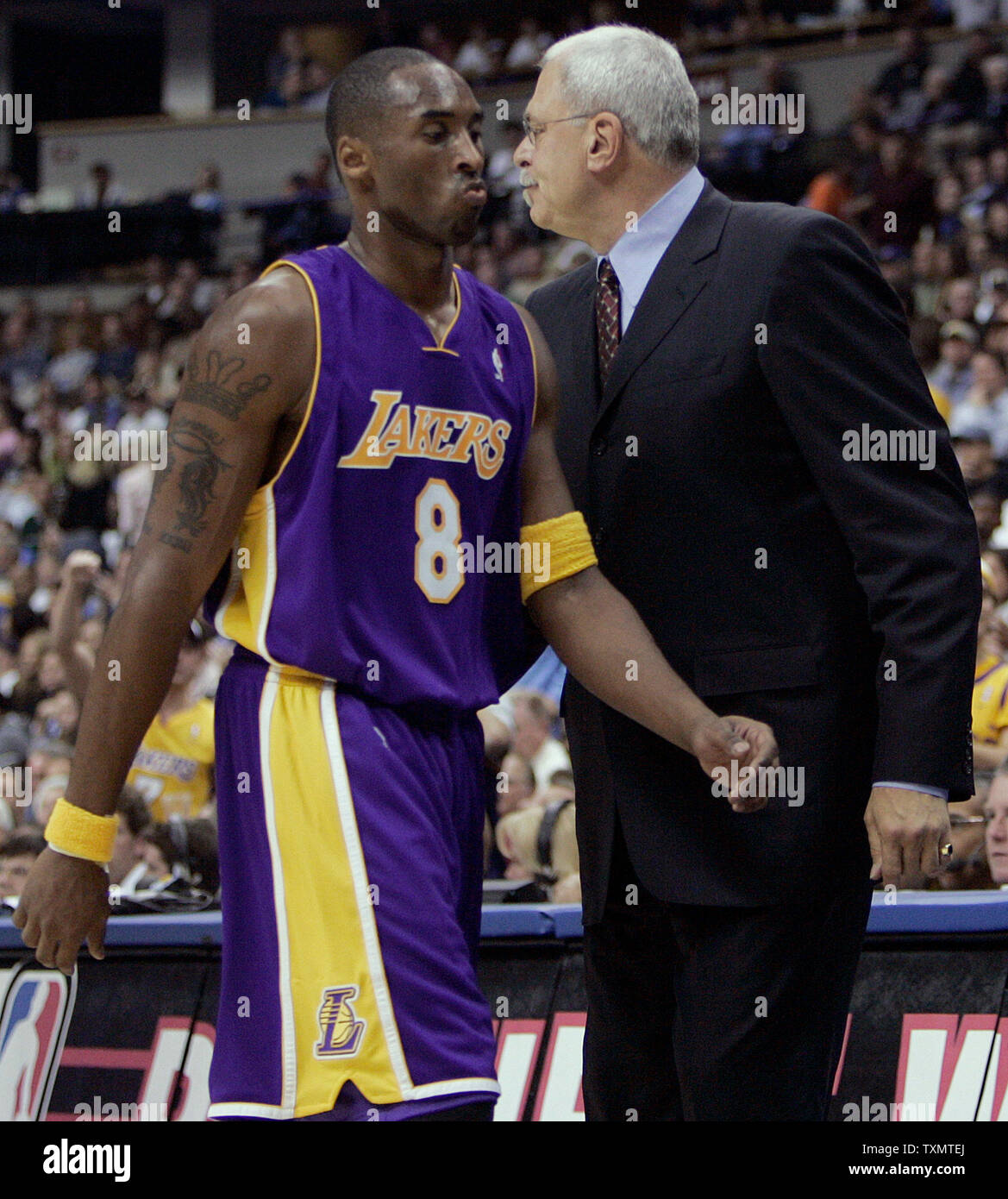 Los Angeles Lakers Kobe Bryant (L) walks past head Phil Jackson (R) after receiving his fourth foul late in the second quarter against the Denver Nuggets at the Pepsi Center in Denver November 2, 2005.  Jackson made his debut with Bryant and the Lakers to begin the 2005-06 NBA season in Denver.   (UPI Photo/Gary C. Caskey) Stock Photo